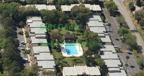 Vista aerea di una zona residenziale con diverse case, una piscina e un parcheggio.