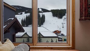 A room with a large window overlooking a snowy ski slope. - Steps to American Flyer lift & Stellar Mtn Views! Hot Tub, Free Wifi, Heated Pkg (Copper Mountain)