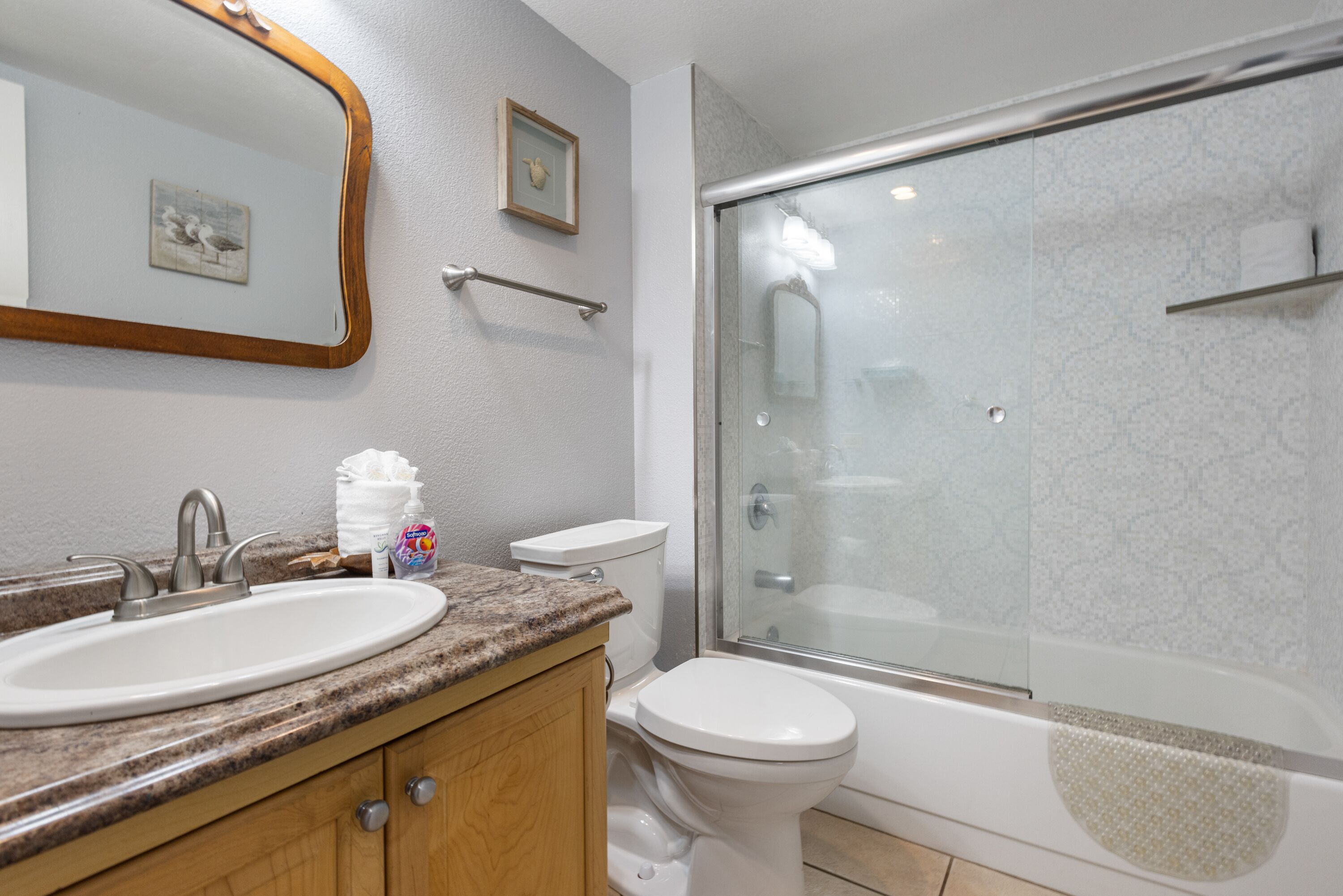 A bathroom with a sink, toilet, and glass-enclosed shower.