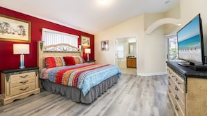 A bedroom with a bed, nightstands, dresser, and a television. - Home in Peaceful Community With Pool, Spa & Privacy Hedges (Davenport)