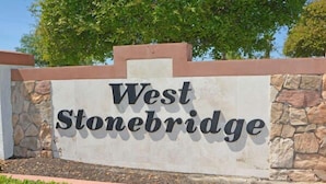 A sign with the text "West Stonebridge" on a stone wall. - Home in Peaceful Community With Pool, Spa & Privacy Hedges (Davenport)