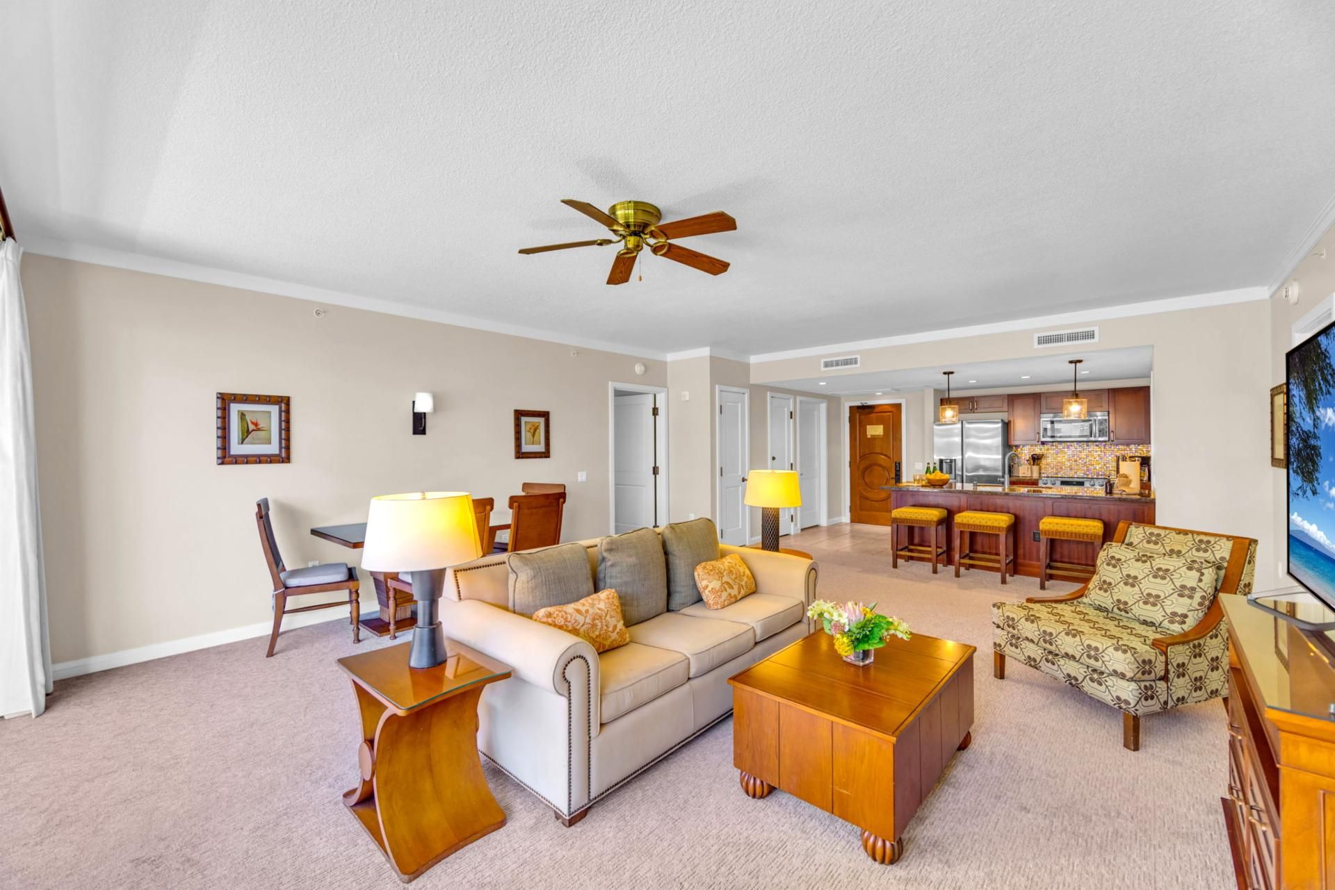 A living room with a sofa, coffee table, and a dining area with chairs and a lamp.