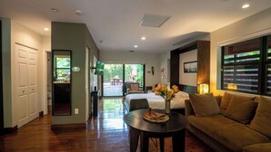 A modern living room with a sofa, a dining table, and a bed. - Coconut Grove Garden Cottage • Private Retreat with Free Parking & Full Kitchen (Miami)