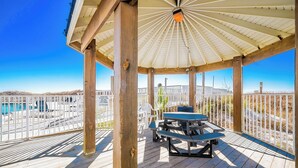A wooden deck with a gazebo, picnic table, and pool view. - BEACH VIEW! One Bedroom at Sugar Beach Condos (Orange Beach)