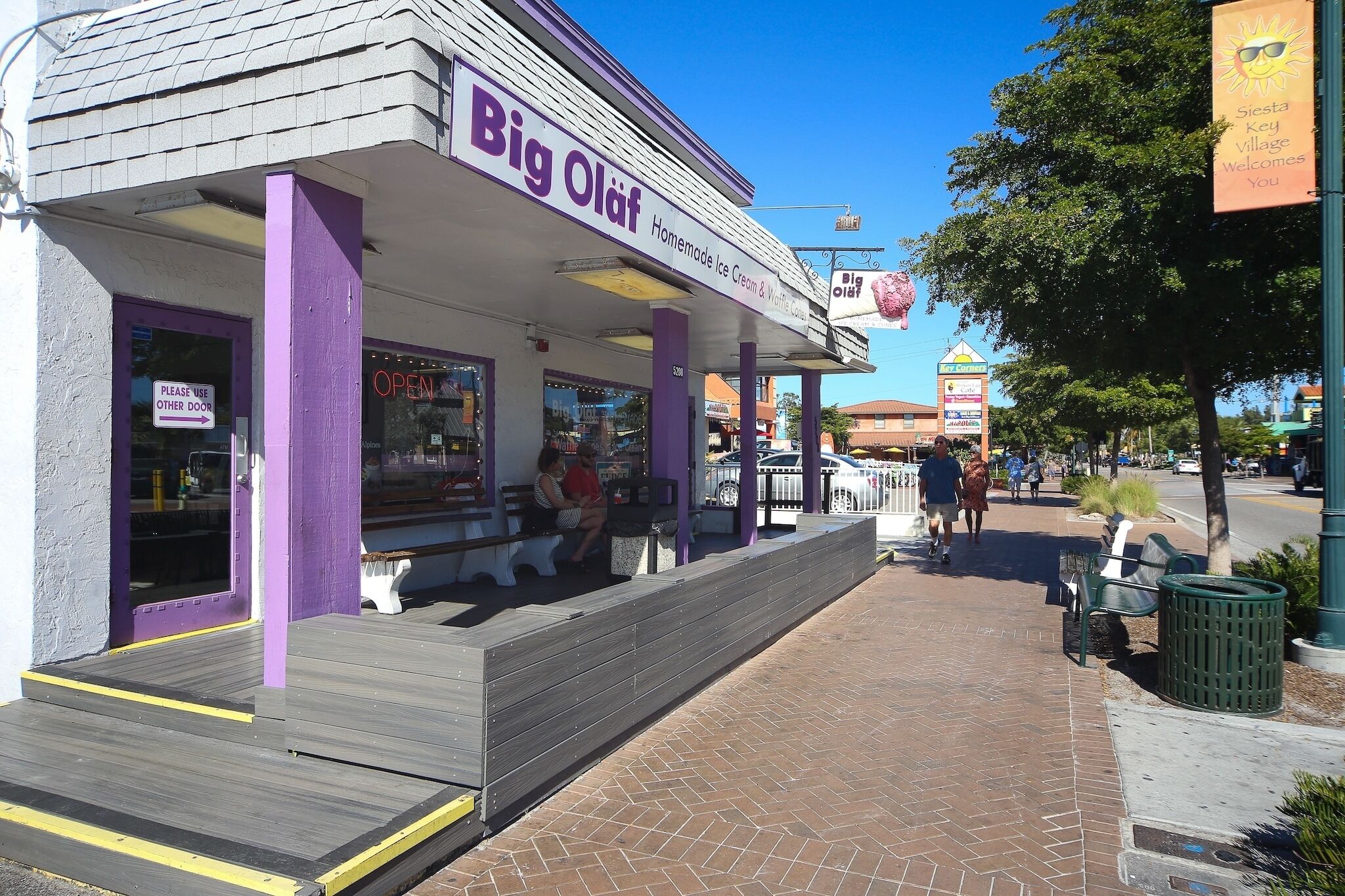 A storefront named Big Olaf with a purple exterior and a sign indicating it's open.