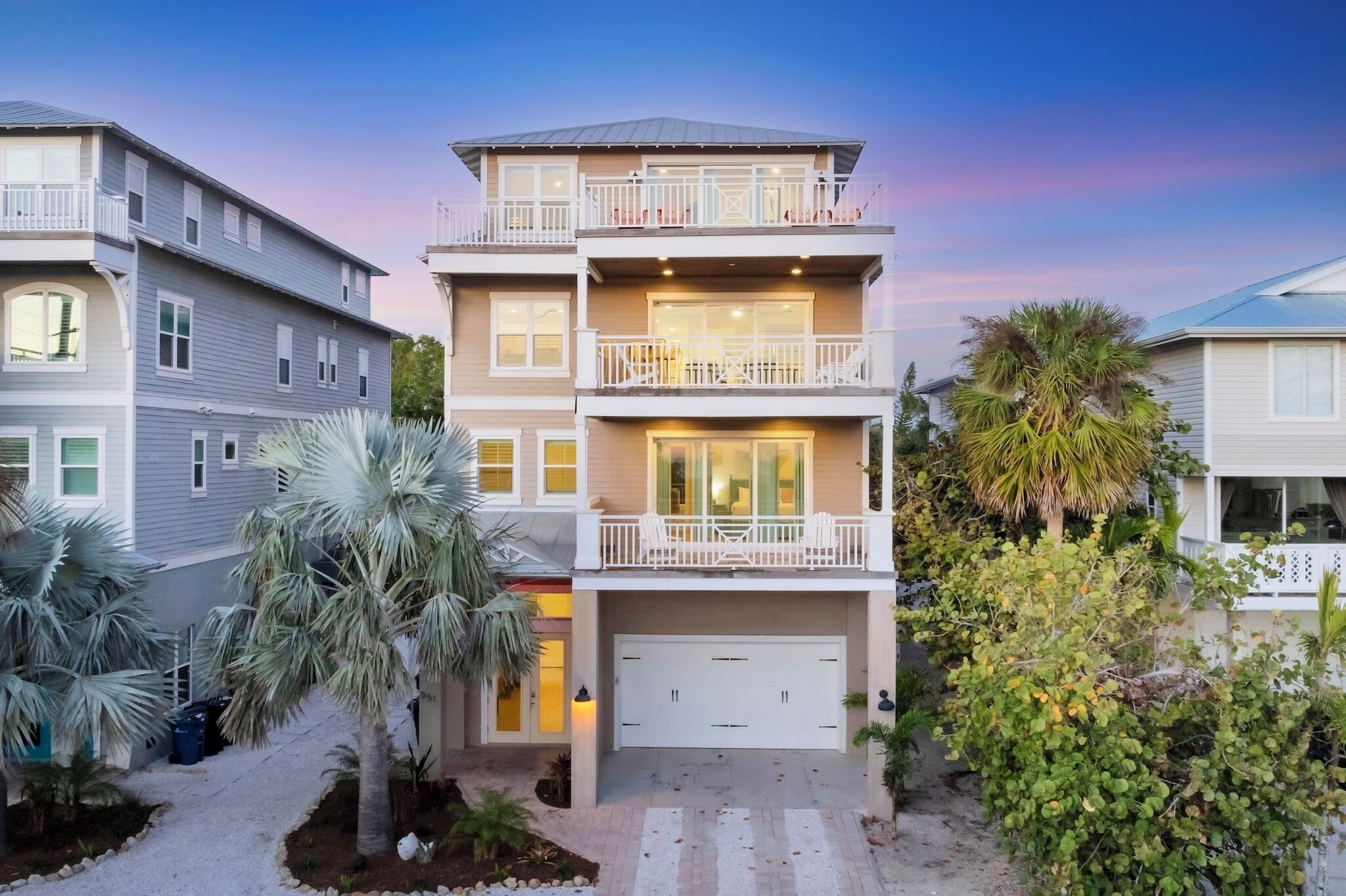 A multi-story residential building with a garage, balconies, and a driveway.