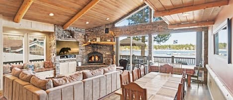 Un interior acogedor con chimenea de piedra, techo de madera y una amplia zona de estar.