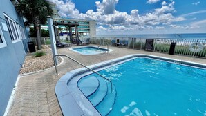 Ein Poolbereich mit zwei separaten Pools, einer überdachten Sitzgelegenheit und Blick auf den Ozean.