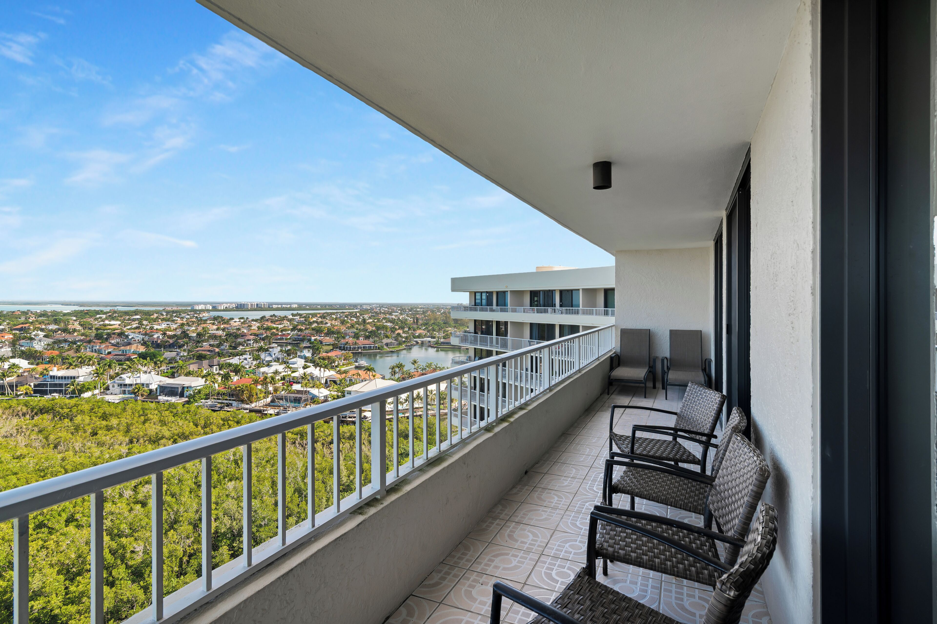 A balcony with a view of a cityscape and a body of water.
