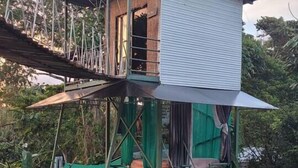 Een klein, verhoogd bouwwerk met één kamer, een balkon en een trap.