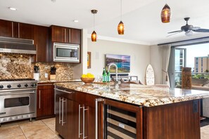 A modern kitchen with granite countertops, stainless steel appliances, and wooden cabinets.