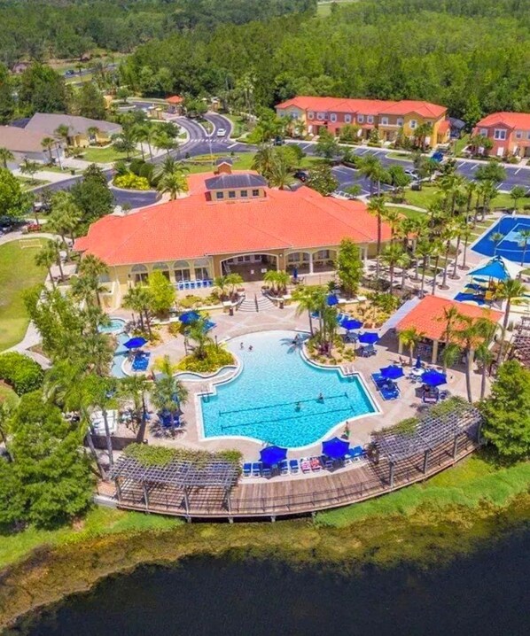 An aerial view of a resort with a central swimming pool, multiple buildings, and a surrounding landscaped area. - 4BR Disney Villa w/ Private Pool & Spa - Terra Verde Resort (Kissimmee)