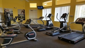 A gym with multiple treadmills, ellipticals, and a stationary bike.