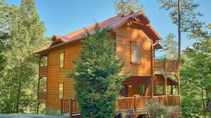 Eine Blockhütte mit Balkon und überdachter Veranda.