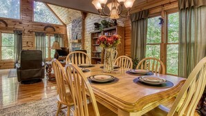 A wooden dining room with a chandelier, a fireplace, and a bookshelf. - Whispering Oaks - Private Pigeon Forge Getaway...Close to Tanger Outlet Shopping (Sevierville)