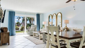 Un vaste espace de vie comprenant une table à manger, des chaises et une vue sur l’extérieur.