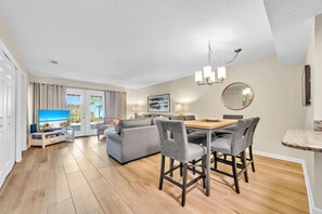 Relax in a spacious living area with a dining table, comfortable sofa, and large flat-screen TV.