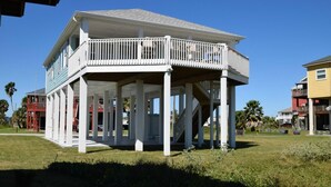 A two-story building with a balcony and a covered porch. - Chateau Des Fontenot (Bolivar Peninsula)