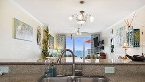 A kitchen with a double sink, granite countertop, and a view of the ocean. - Beachy, Relaxing, Beachfront Condo, Great Location, Awesome Balcony Features (Panama City Beach)