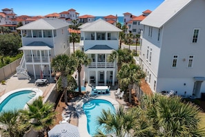 A resort with multiple buildings, a swimming pool, and palm trees. - AQUASCAPE: Beautiful Home with Private Pool and Large Deck 1 Block from Beach! (Santa Rosa Beach)