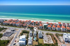 An aerial view of a coastal residential area with houses, a road, and a beach. - AQUASCAPE: Beautiful Home with Private Pool and Large Deck 1 Block from Beach! (Santa Rosa Beach)