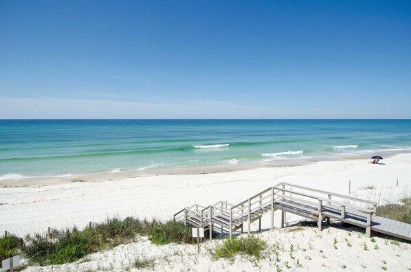 A beach with a wooden walkway leading to the shore, clear skies, and calm ocean waves. - AQUASCAPE: Beautiful Home with Private Pool and Large Deck 1 Block from Beach! (Santa Rosa Beach)