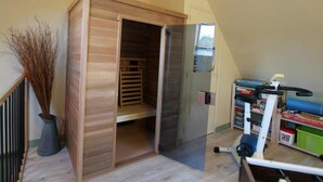 A room with a wooden wardrobe, a bookshelf, and a vacuum cleaner. - Stone house near the sea with sauna and large garden (Baubigny)