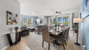 A dining area with a glass table, chairs, and a ceiling fan. - Lakeview - Next to Clubhouse, Gym and Pool - 1st Floor (Orlando)