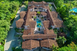 Un grand hôtel à plusieurs étages, doté d’une cour intérieure, de nombreux balcons et d’une piscine.