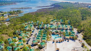 A resort with multiple buildings, a swimming pool, and a beach area.