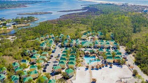 A resort with multiple buildings, a swimming pool, and a beach area.