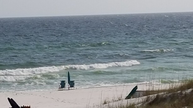 A beach with waves, a sandy shore, and two chairs. - Reduced  rates  on 30A beach front condo. (Santa Rosa Beach)