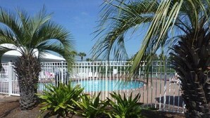 A pool area with palm trees and a fenced pool. - Reduced  rates  on 30A beach front condo. (Santa Rosa Beach)