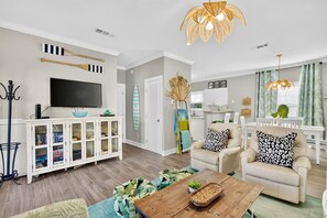 A modern living room with a television, bookshelves, a coffee table, and a sofa.