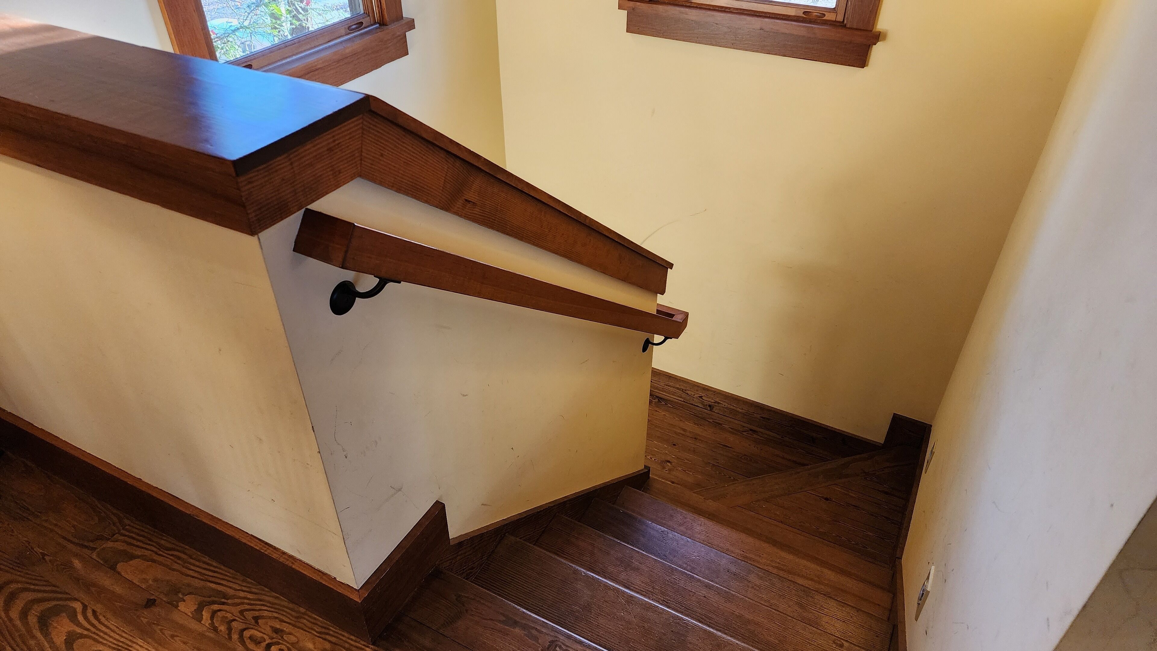 A corner of a room with a wooden counter and a wooden staircase.