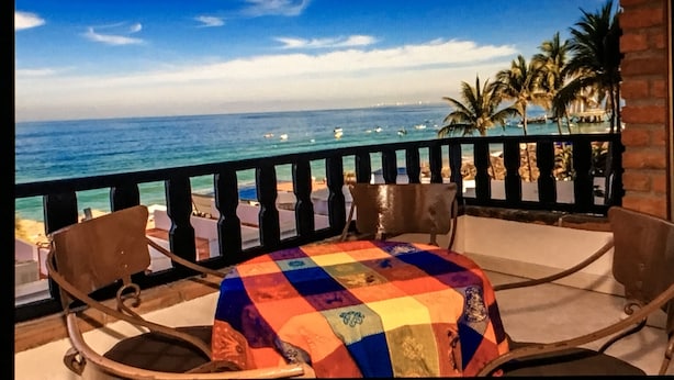 Ein Balkon mit Blick auf das Meer und Palmen.