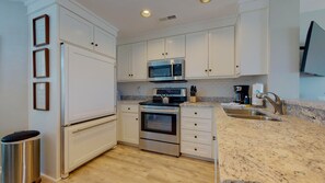 Enjoy cooking in this well-equipped kitchen with a sink, faucet, microwave, oven, and coffee maker.