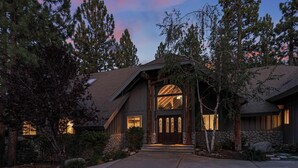 A two-story house with a stone foundation, a large front door, and a driveway leading to the entrance. - Winterpark: Conveniently located near Snow Summit and Bear Mountain! Game Room with Pool Table and Foosball! (Big Bear Lake)