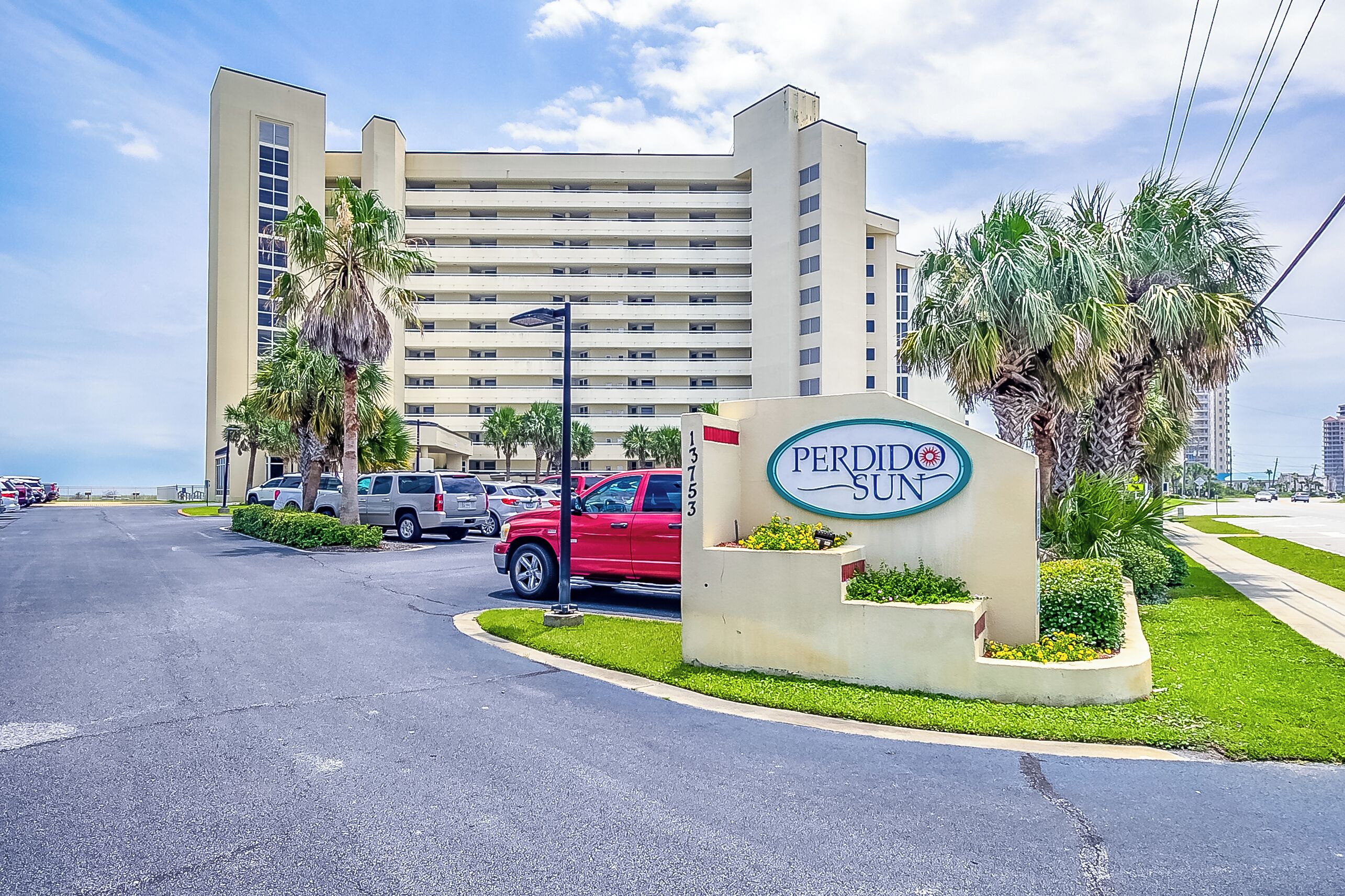 A hotel sign with a large building in the background.