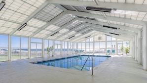 Une piscine intérieure offrant une vue dégagée sur l’extérieur.