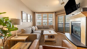 A cozy living room with a sofa, coffee table, and fireplace.
