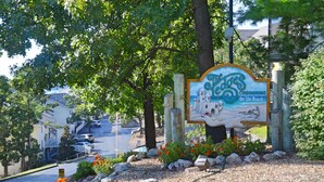 A sign for 'The Eddies Condominiums on the Beach' with a beach scene illustration. - Comfy Ledges Lakefront Condo--quiet cove, boat slip included! (Osage Beach)