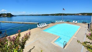 A swimming pool with a view of a lake and a flag. - Comfy Ledges Lakefront Condo--quiet cove, boat slip included! (Osage Beach)