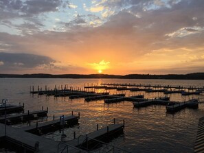 A marina with multiple docks extending into calm waters during sunset.