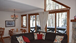 A cozy living room with a sectional sofa, a dining table, and a fireplace.