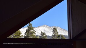 A mountain view through a window with a triangular frame.