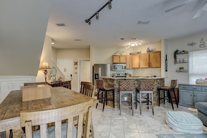 Enjoy cooking in this well-equipped kitchen with a central island, microwave, and stainless steel refrigerator.