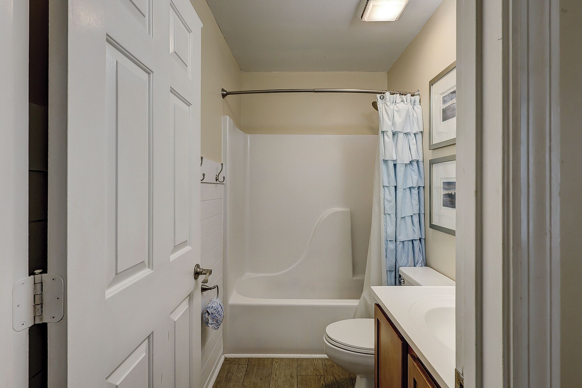 A bathroom with a bathtub, toilet, and a shower curtain.