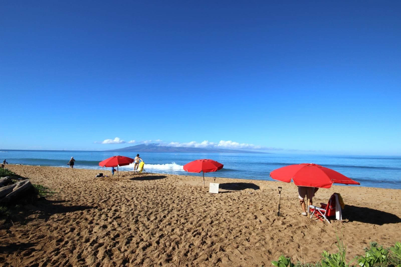 Steps from the sand—enjoy calm waters, red umbrellas, and postcard-worthy views at Kaanapali Beach