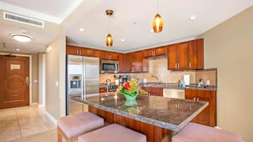 A modern kitchen with granite countertops, stainless steel appliances, and wooden cabinets.